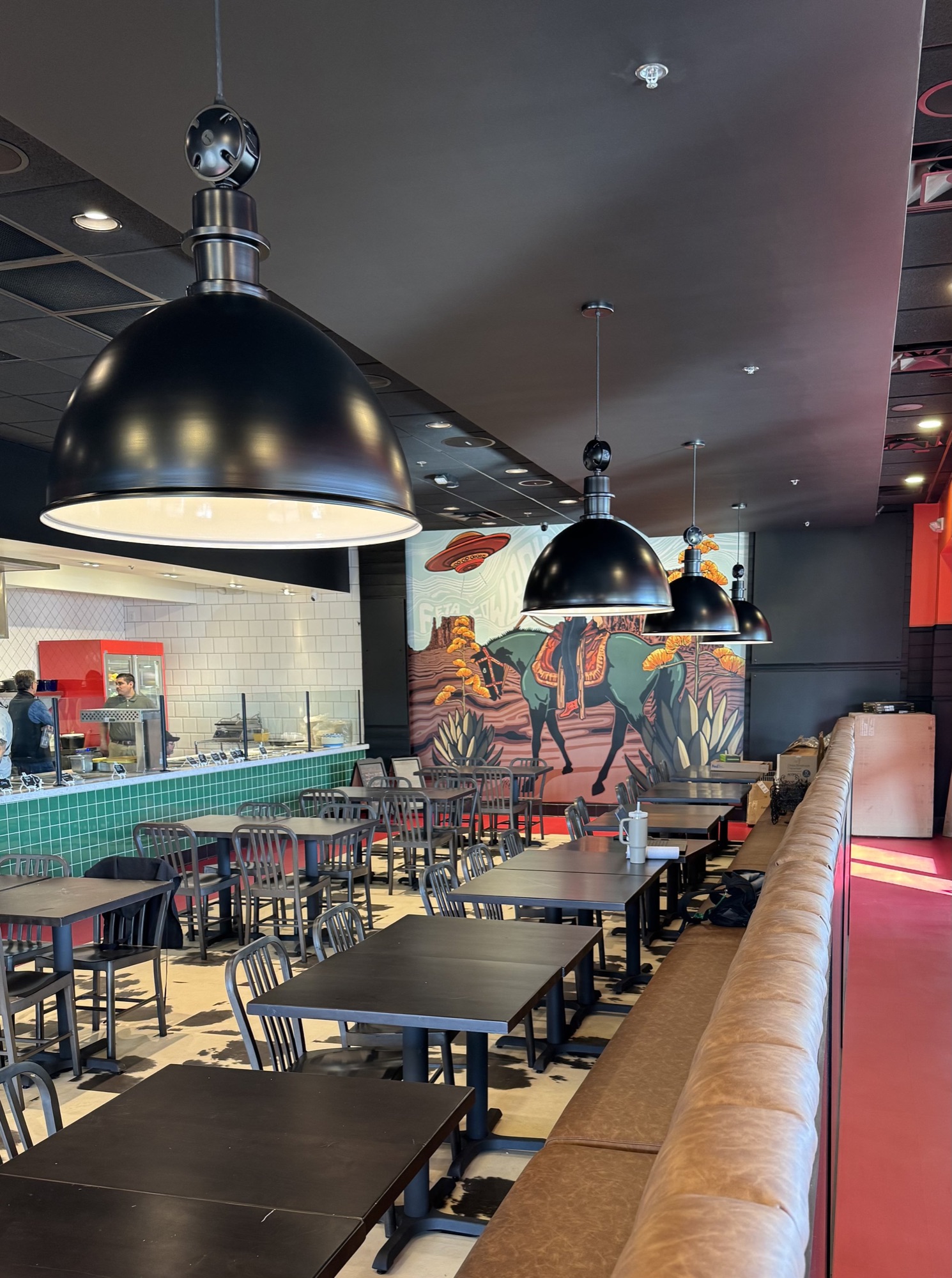 Long dining room with banquette and dome pendants at Feta Cowboy